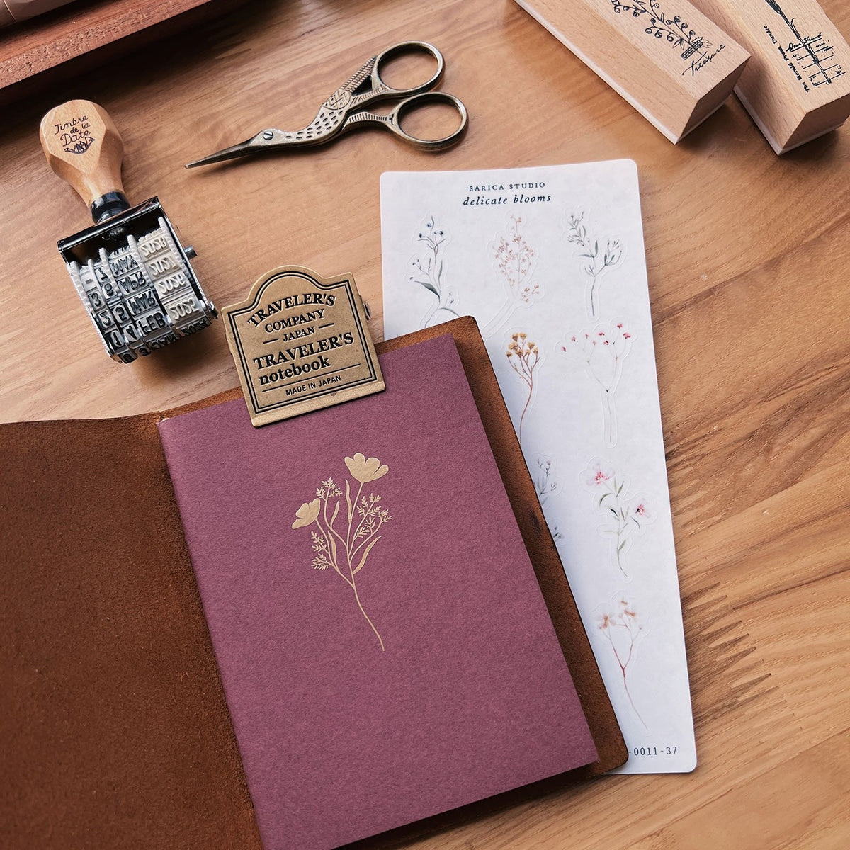 Sarica Studio Floral Notebook, passport TN size, in a brown leather passport cover with a floral sticker sheet and rubber stamps