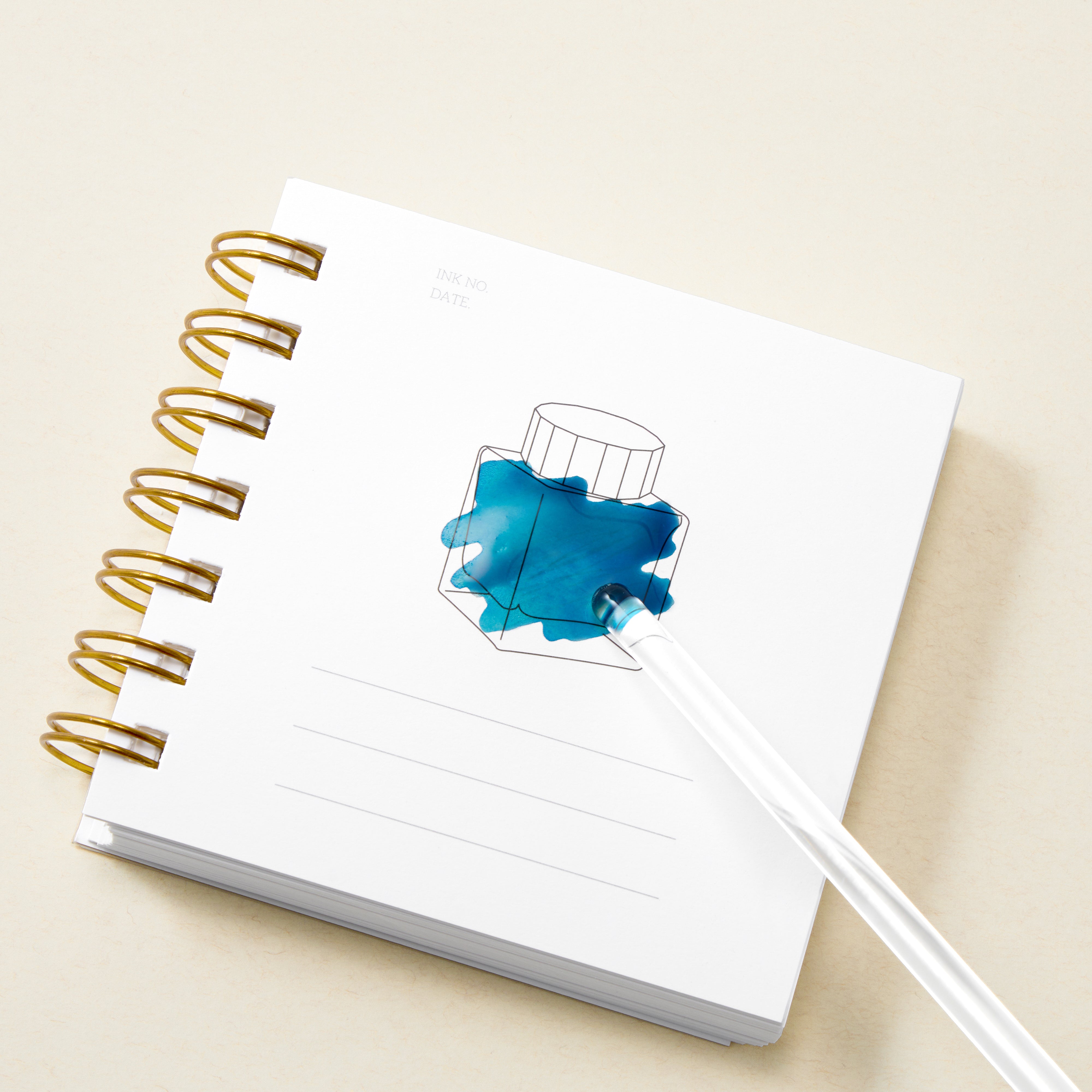 Ring bound book with white page with drawing of ink bottle filled with blue ink