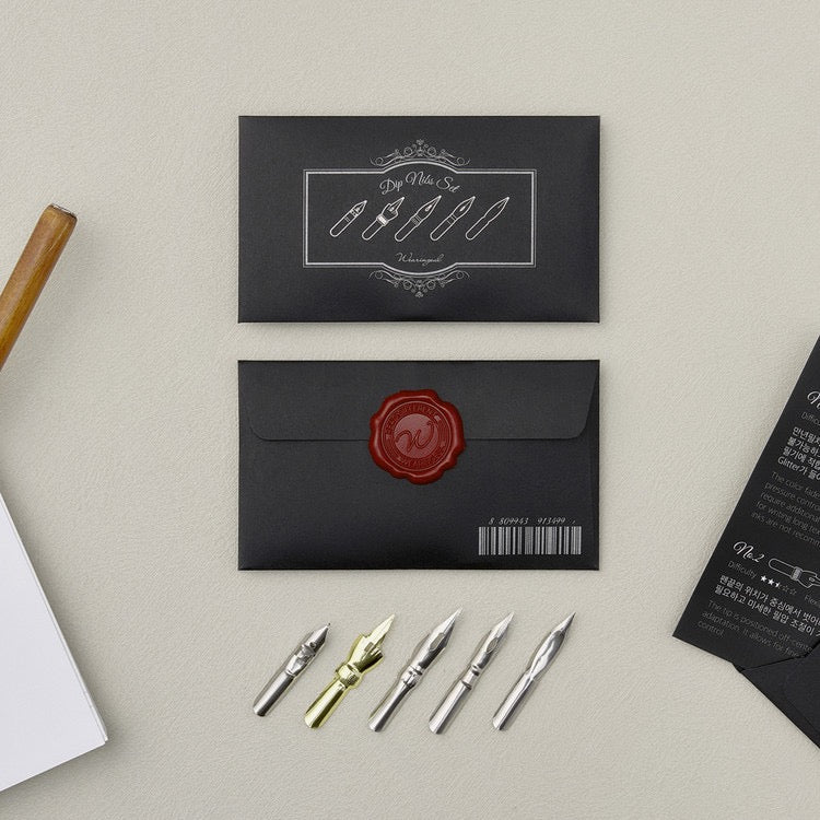 Black envelope with wax seal and selection of nibs
