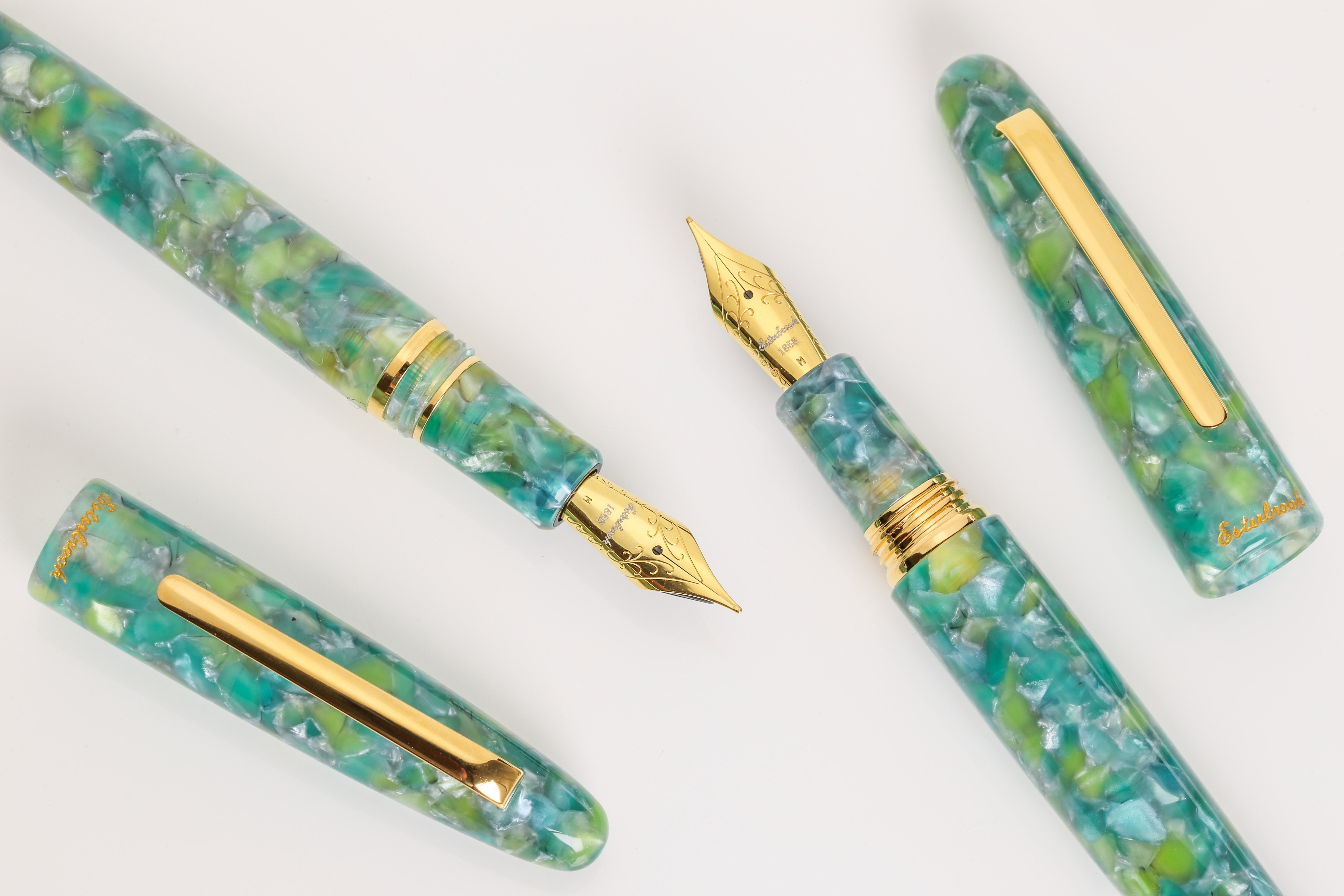 Fountain pen set with green marbled design and gold accents on a white background