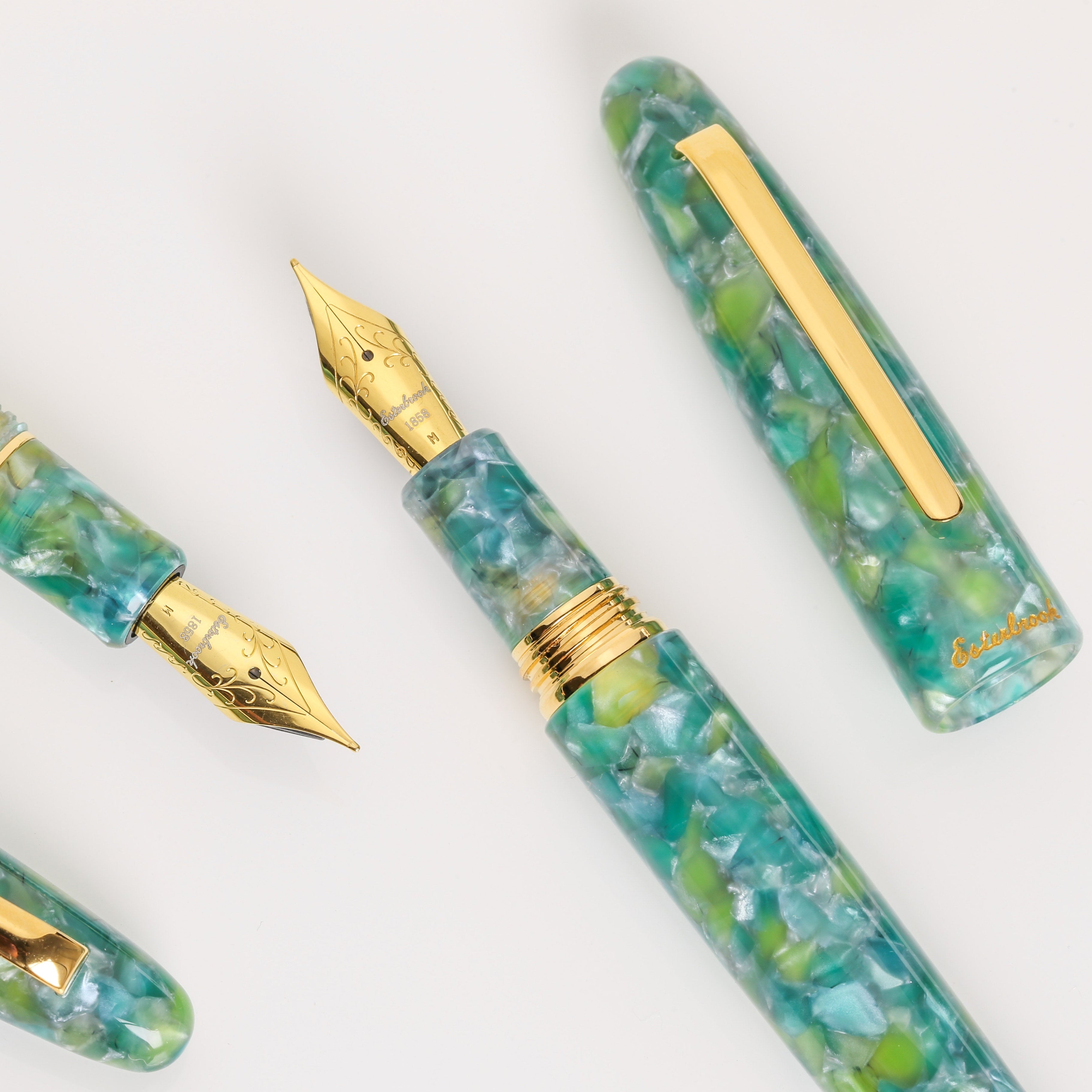 Fountain pen set with green marbled design and gold accents on a white background