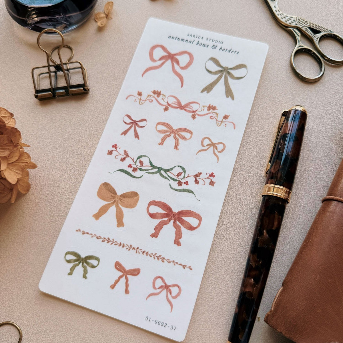 Sarica Studio Autumnal Bows & Borders stickers, close-up of bows and borders beside a fountain pen