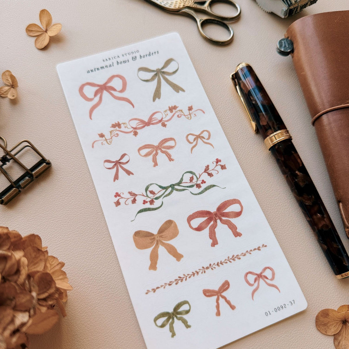 Sarica Studio Autumnal Bows & Borders stickers, sheet with a fountain pen and a leather traveler's notebook