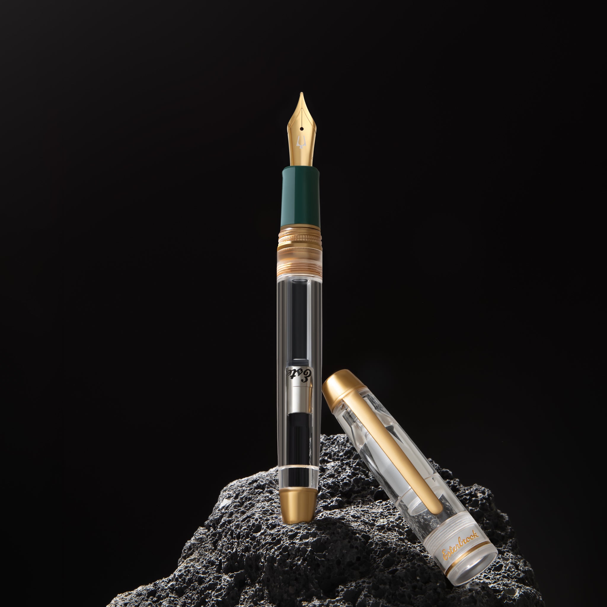 Esterbrook x Accutron Spaceview Estie demonstrator fountain pen uncapped, gold nib, green grip, converter visible in clear barrel