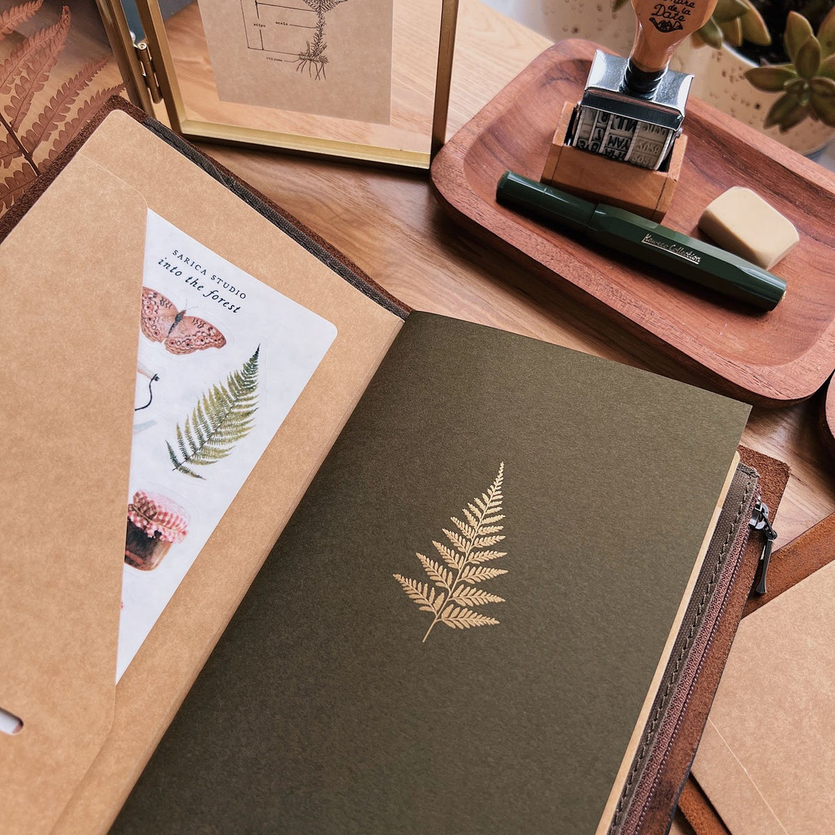 Sarica Studio Fern Notebook, standard TN size, in a traveler's notebook cover with a kraft pocket folder and a sticker sheet