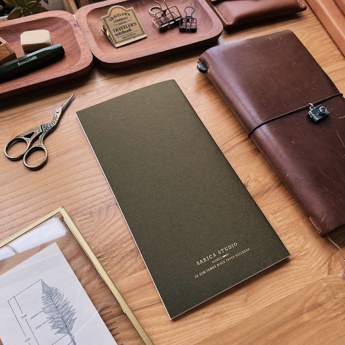 Sarica Studio Fern Notebook, standard TN size, back cover beside a brown leather traveler's notebook