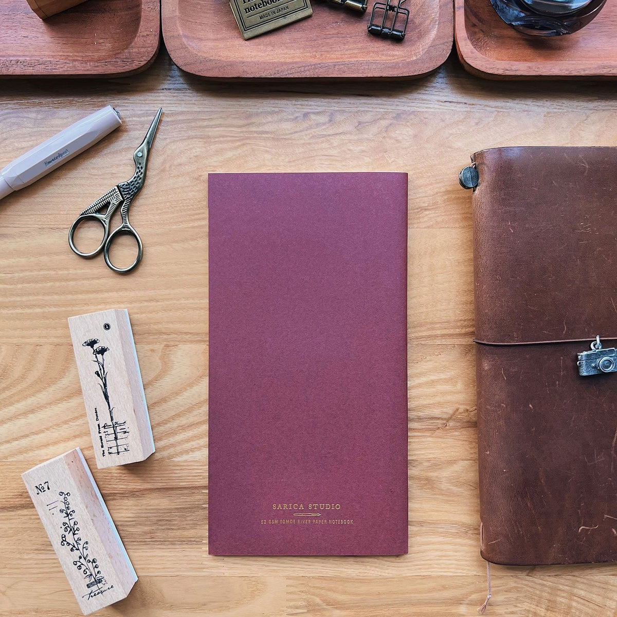 Sarica Studio Floral Notebook, standard TN size, back cover beside a leather traveler's notebook