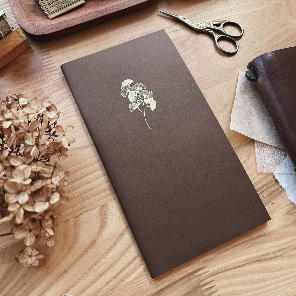 Sarica Studio Ginkgo Notebook, standard TN size, chestnut brown with a gold ginkgo design, shown at an angle