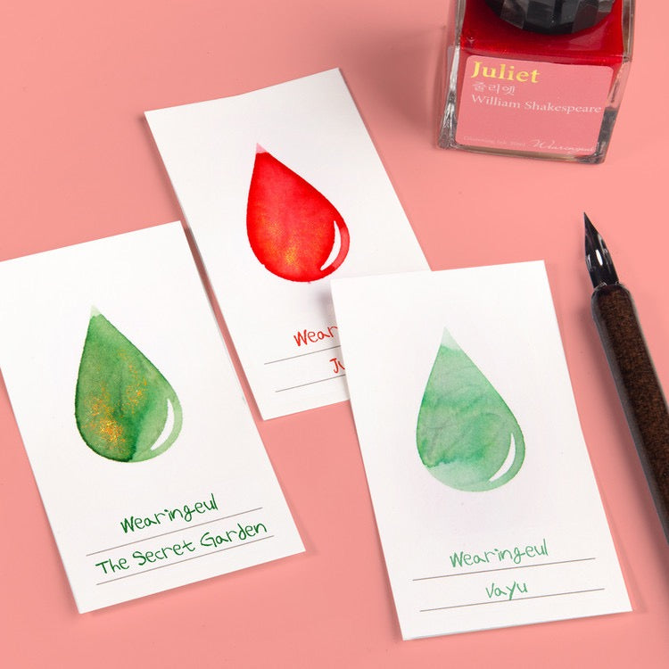 White ink swatch cards with various colors of ink in an ink drop shape