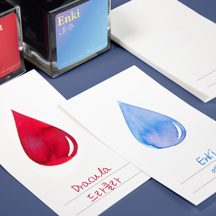 White ink swatch cards with various colors of ink in an ink drop shape