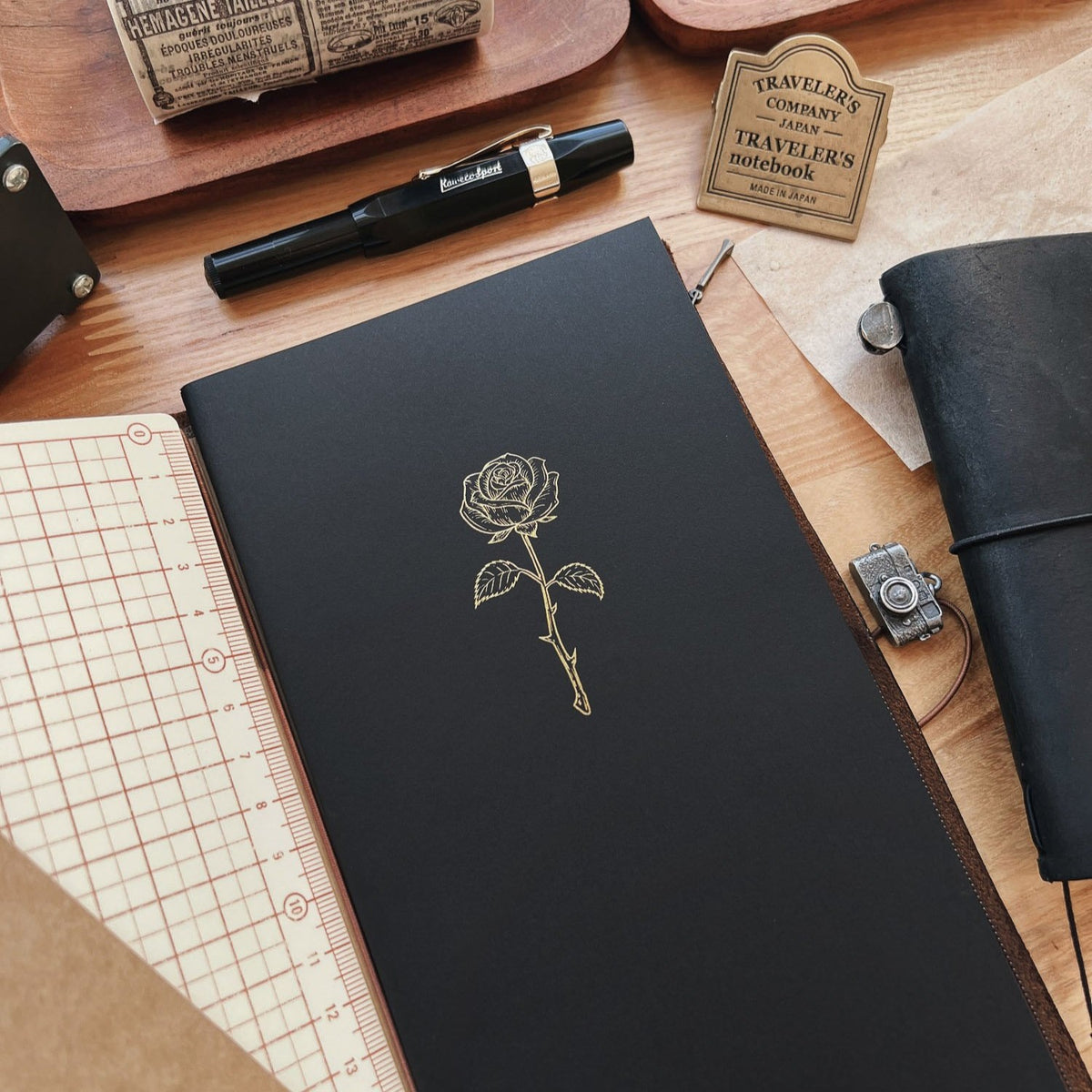 Sarica Studio Rose Notebook, standard TN size, in a black leather traveler's notebook with a grid folder