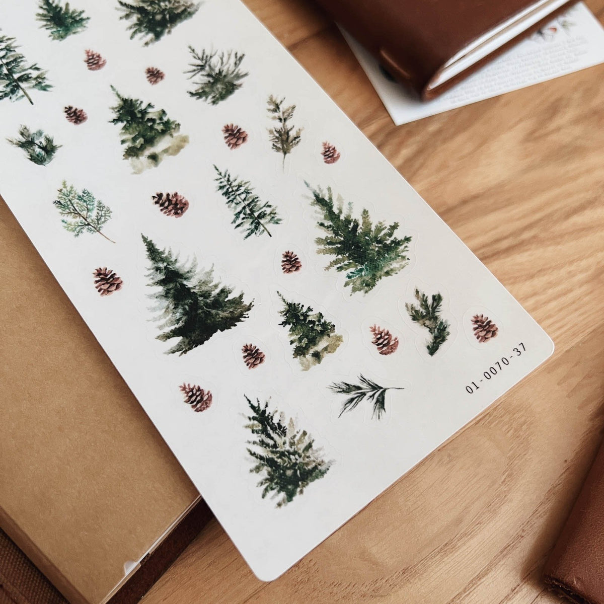 Close-up of Sarica Studio Evergreens & Pinecones stickers of dark green trees and brown pinecones