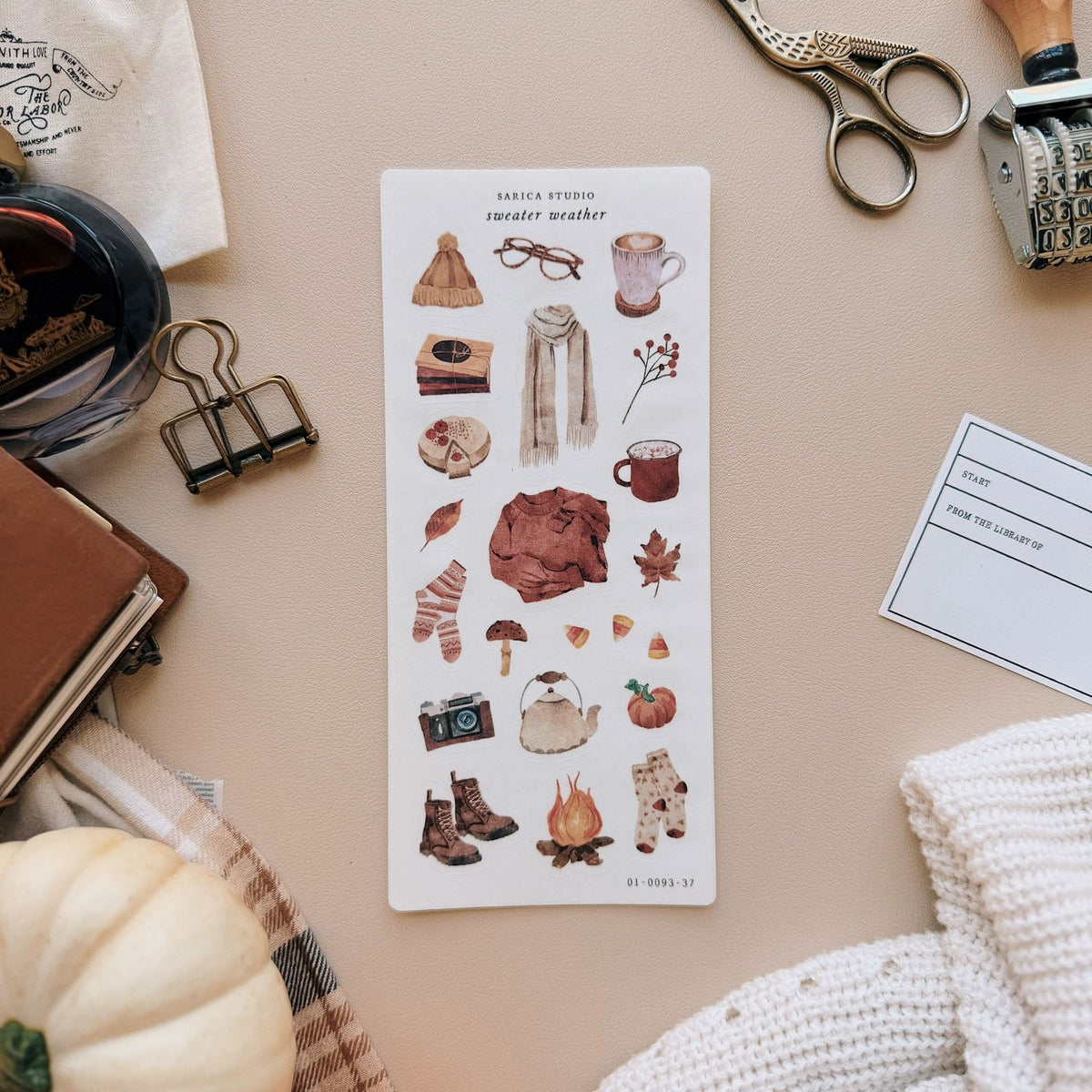Sarica Studio Sweater Weather stickers, sheet on a desk with a white pumpkin and a knit sweater