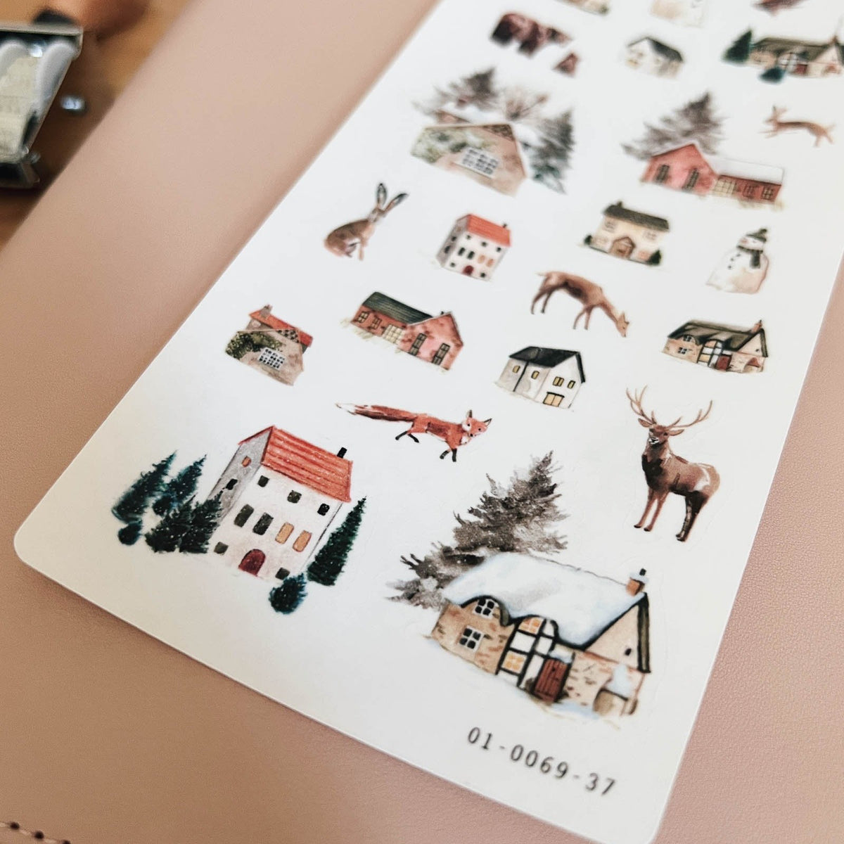 Close-up of Sarica Studio Winter Wonderland stickers of little red and white houses in the snow