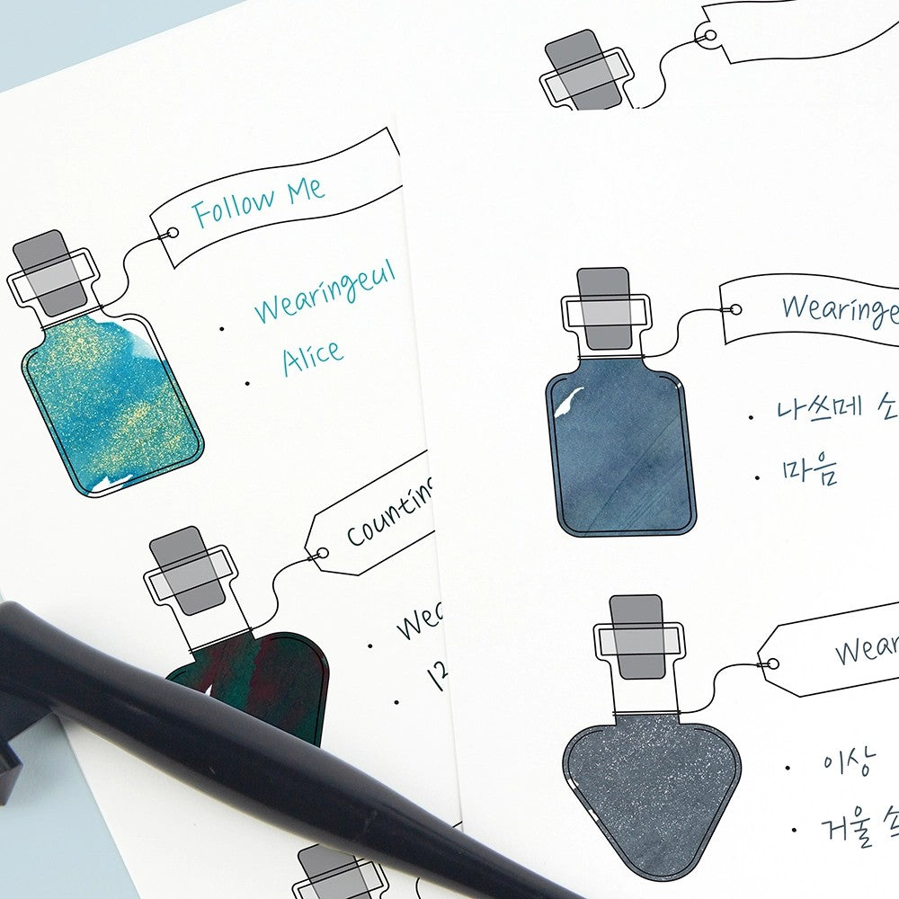 Alice's Potion swatch sheet with bottles filled with blue fountain pen inks and labeled by hand