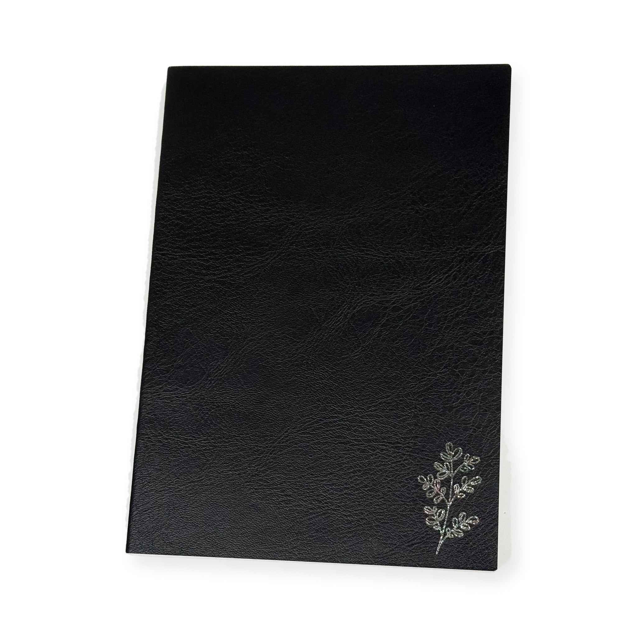 Planner Monkey Co Freely Noted A5 notebook in black, front cover shown flat on white with a botanical sprig stamped in silver foil in the lower corner