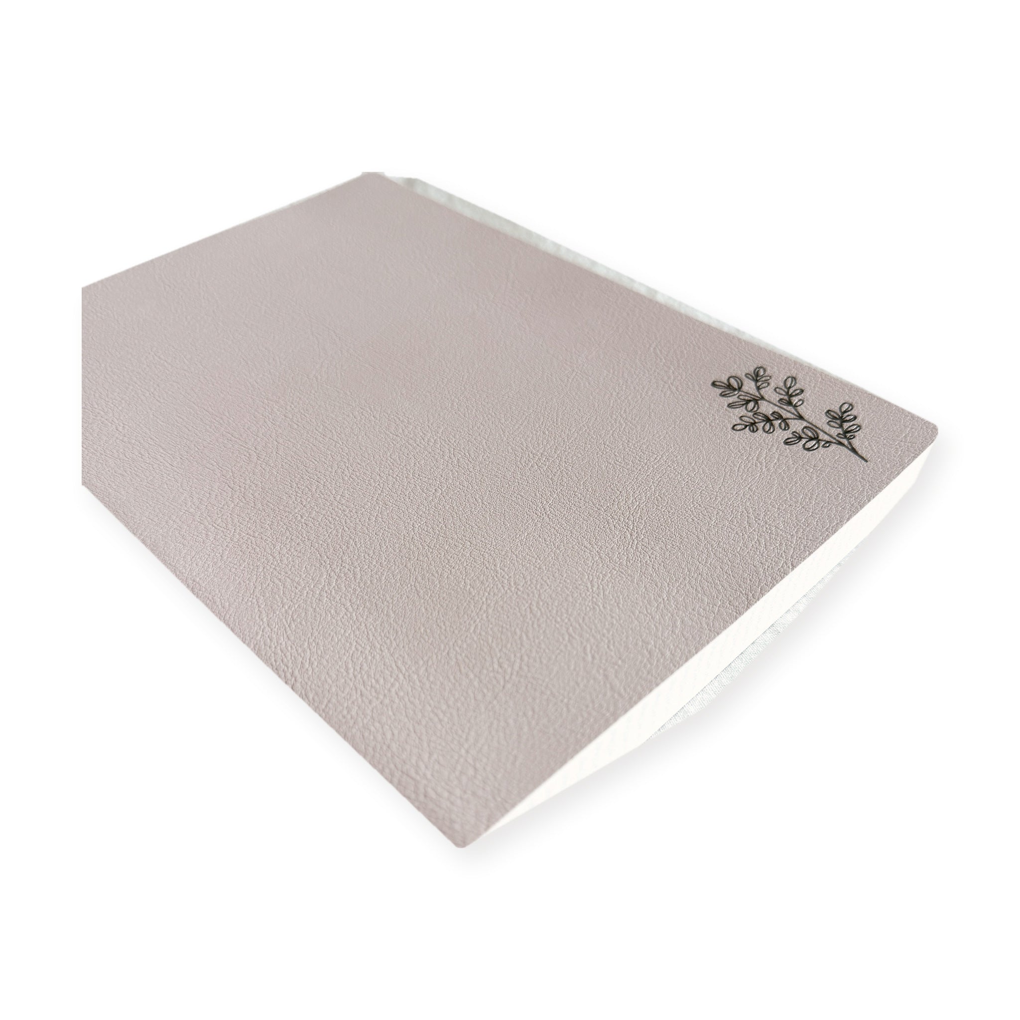 Blush pink Freely Noted A5 notebook at an angle, showing the pebbled texture of the softcover and the Tomoe River page block along the fore edge